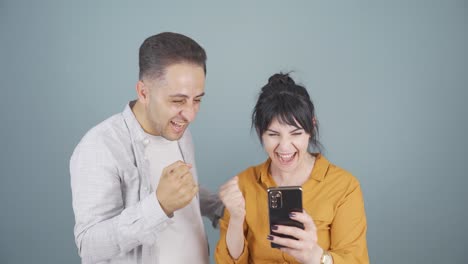 The-couple-looking-at-the-phone-is-happy.